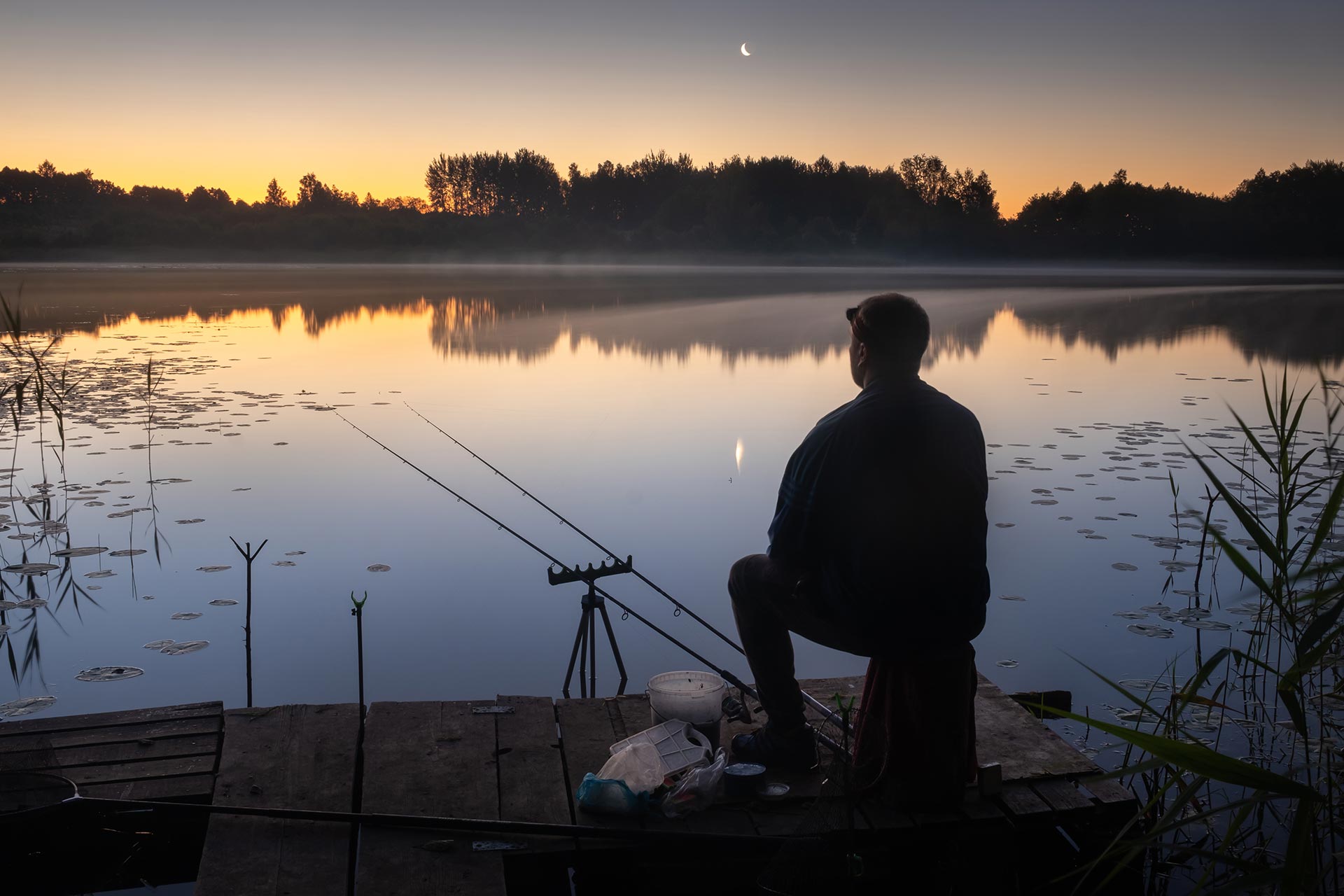 at-night-a-fisherman-sits-on-the-pier-with-fishin-2023-11-27-05-22-18-utc.jpg